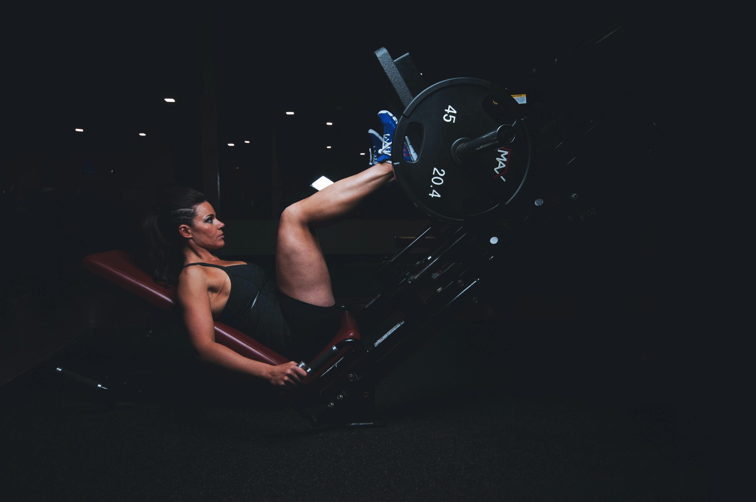 pexels-photo-136404-136404 A woman engages in an intense leg press workout at the gym, showcasing strength and fitness.
